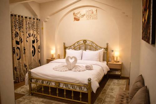 a bedroom with a bed with a heart decoration on it at The 5 Inn - Rooftop Pyramids View in Cairo