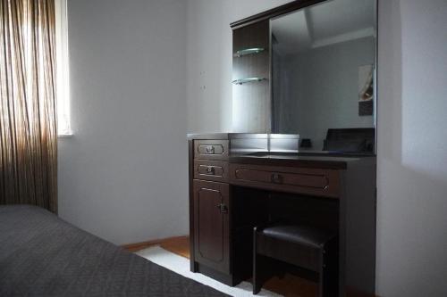 a bedroom with a vanity with a mirror and a bed at Prishtina Center Apartment, 100m from Skanderbeg Square in Prishtinë