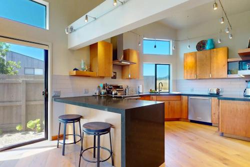 a kitchen with a large island with two bar stools at West Meadow in Sea Ranch