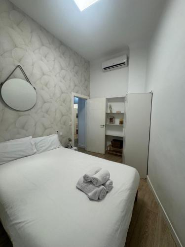 a bedroom with a white bed with towels on it at Apartamentos Sal de Luna in Toledo