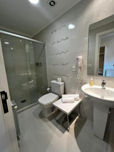 a bathroom with a toilet and a sink and a shower at Villa São Carlos in Caxias do Sul