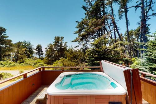 a hot tub on a wooden deck with trees at The Great Escape in Sea Ranch