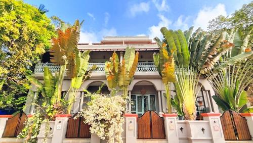a house with palm trees in front of it at Plot 77 by hnh in Baga