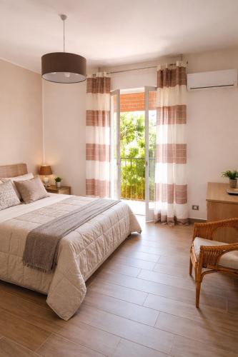 a bedroom with a large bed and a large window at Il Mare a Pochi Passi in Marina di Ragusa