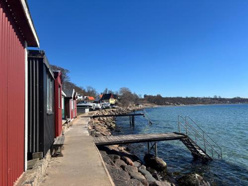 a wooden bench sitting next to a body of water at Villa Glumslov in Landskrona