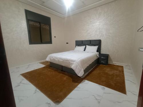 a bedroom with a bed in a white room at شقق تاج الداخلة in Dakhla