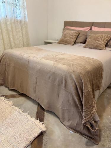 a bed with a blanket on it in a bedroom at Casa natureza Paraty I in Paraty