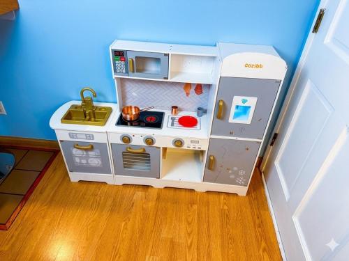 a play kitchen with a pretend refrigerator in a room at Spacious 3BR Luxury Villa Gated Parking Near Dodger St DTLA in Los Angeles