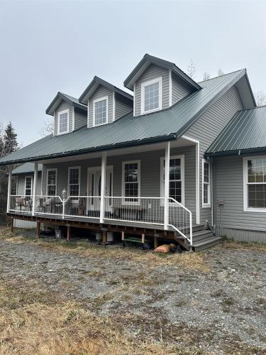 a house with a large porch with a porch at Constellation Lake Home in Kasilof