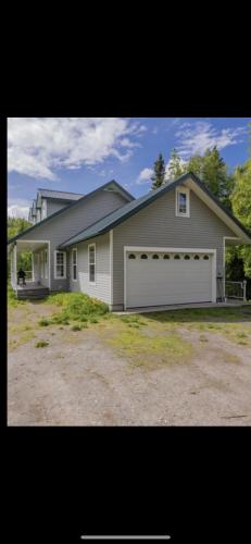 a large house with a white garage at Constellation Lake Home in Kasilof