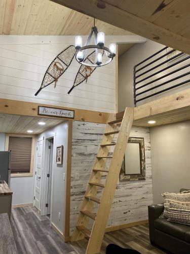 a loft bed in a room with a wooden wall at Catch'em AK - Bears Den in Soldotna
