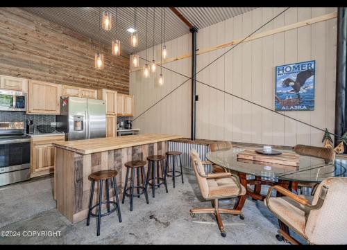 a kitchen with a counter and chairs and a table at Catch'em AK - Eagles Nest in Soldotna