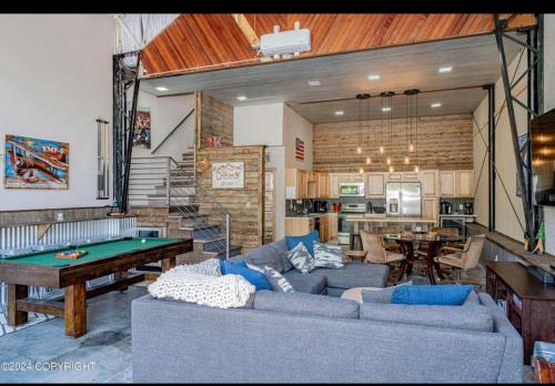 a living room with a couch and a pool table at Catch'em AK - Eagles Nest in Soldotna