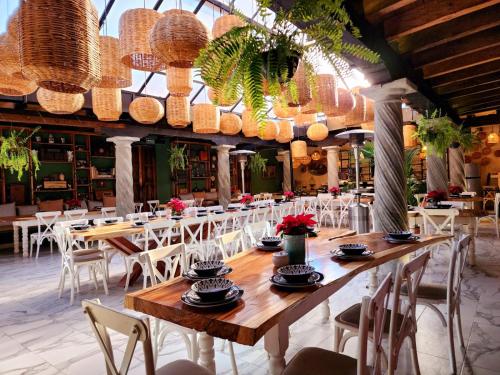 a dining room with tables and chairs and chandeliers at Hotel Quinta los Morales in San Cristóbal de Las Casas