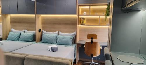a bedroom with a bed and a couch and a desk at Apartamento Águas Claras S4 particular in Águas Claras
