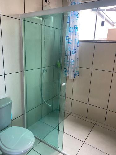 a bathroom with a glass shower with a toilet at Studio sattwa 2 in Prudentópolis