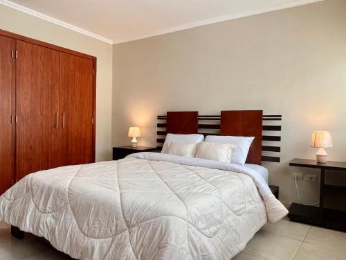 a bedroom with a large white bed with two lamps at Gallery Suite en Riverfront Puerto Santa Ana in Guayaquil
