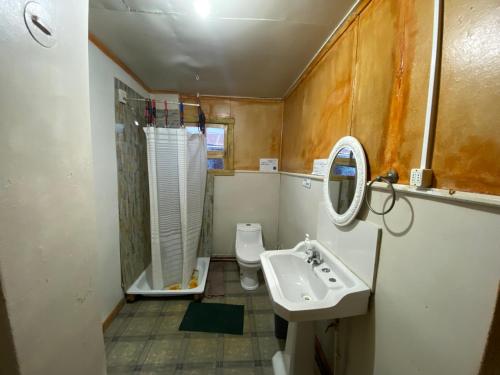a small bathroom with a sink and a toilet at ይሥሓቅ House in Puerto Natales