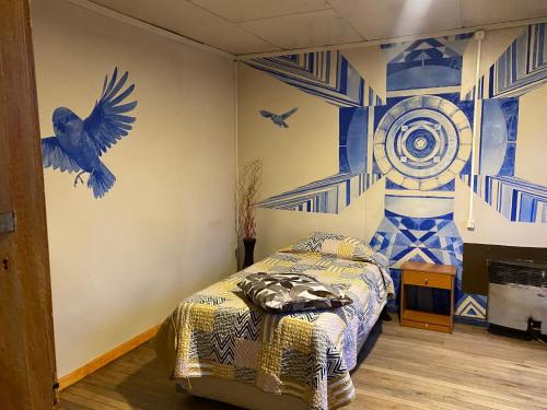 a bedroom with a bed with blue and white walls at ይሥሓቅ House in Puerto Natales
