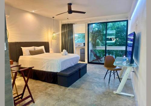a bedroom with a bed and a desk with a computer at Rico Isla Rooms Eco-Chic in Isla Mujeres
