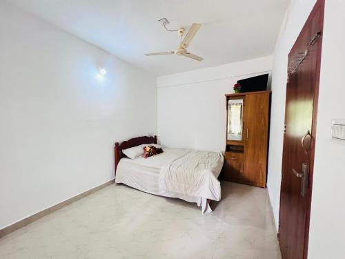 a bedroom with a bed and a ceiling fan at HiDot Holidays in Padinjarathara