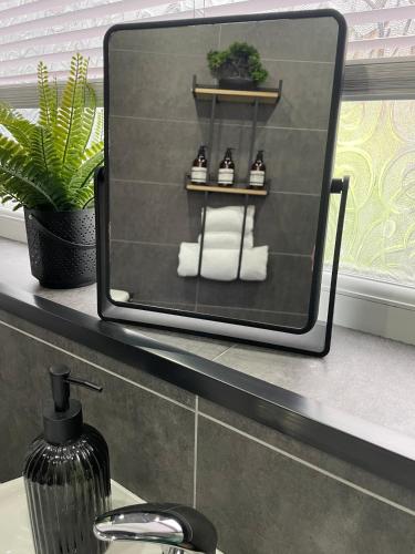 a mirror sitting on a shelf in a bathroom at Modern Homes in Stoke on Trent