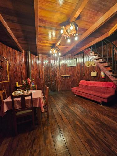 a living room with a red couch and a table at Pousada Botte di Vino in Garibaldi