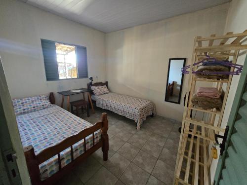 a bedroom with two beds and a desk and a bunk bed at MAEVE Albergue in Goiás
