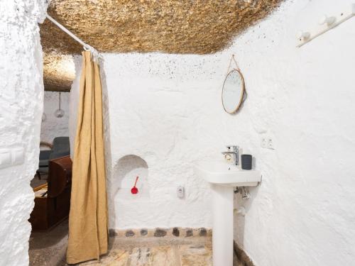 a bathroom with a sink and a shower curtain at La cueva del marinero in El Socorro