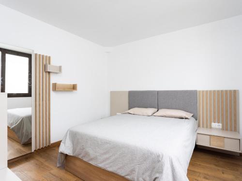 a white bedroom with a bed and a window at Luz de Mafasca in La Hidalga
