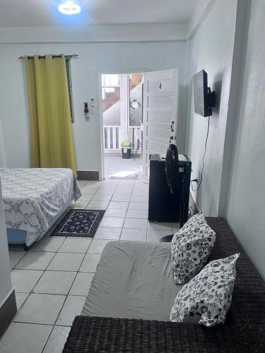 a bedroom with a bed and a door to a room at Garden Lodge Hotel in Placencia