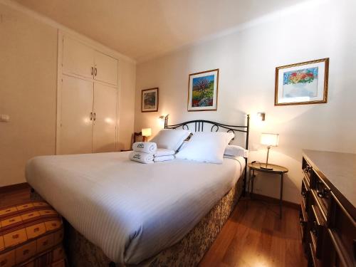 a bedroom with a large white bed with a radio on it at AC Apartaments Apollo Soldeu in Soldeu