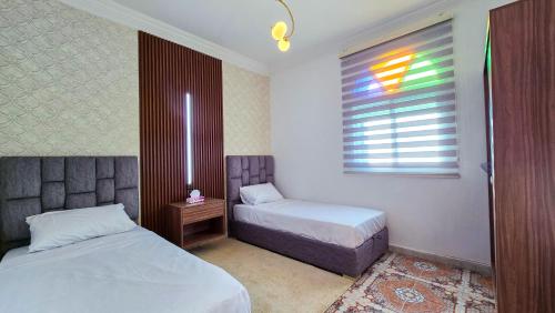 a small bedroom with two beds and a window at Central Premium Holiday Homes - Marché, Corniche & Océan à pied in Larache