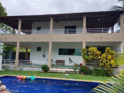 a house with a swimming pool in front of it at Casa da Mari in Caucaia