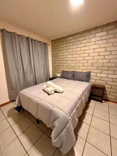 a large bed in a room with a brick wall at Hermosa casa en Jiutepec in Jiutepec