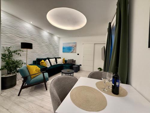 a living room with a couch and a table and chairs at Holiday Apartment Lira jacuzzi - sea view- terrace in Mlini