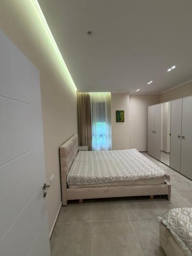 a large bedroom with a bed and a window at Tirana Urban Nest in Tirana