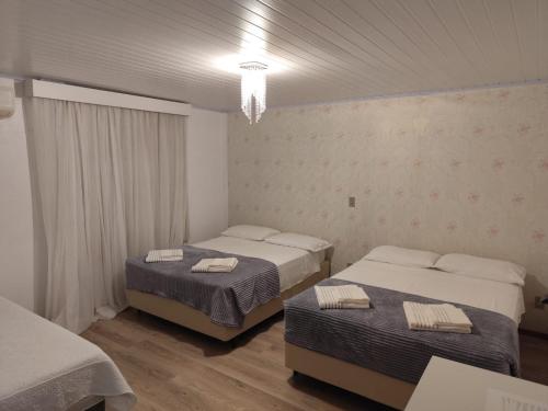a bedroom with two beds and a chandelier at Recanto Vó Eni in Gramado