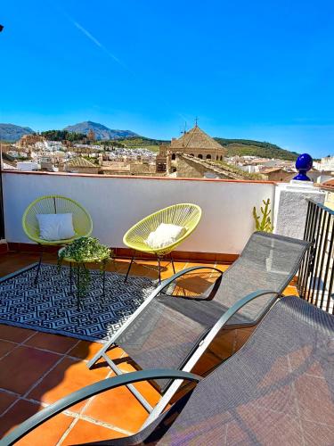 a balcony with chairs and a view of the ocean at CASA VERA, Casa completa para familias o grupos en el centro de Antequera in Antequera