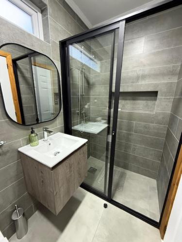 a bathroom with a shower and a sink and a mirror at alojamiento Santa Rosa 744 in Puerto Varas