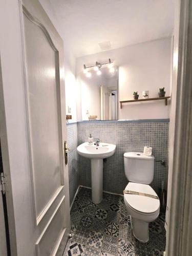 a bathroom with a toilet and a sink and a mirror at Toledo Histórico in Toledo