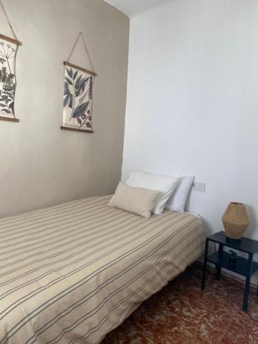 a bed in a room with a white wall at CASA VERA, Casa completa para familias o grupos en el centro de Antequera in Antequera
