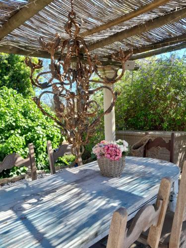 a wooden table with a wicker basket of flowers on it at Casa De Mondo in Boliqueime