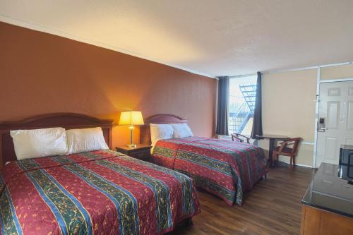 a hotel room with two beds and a balcony at Vienna Travel Inn in Vienna