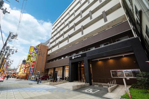 a building on a street in a city at KOKO HOTEL Osaka Shinsekai - formerly Hotel Wing Premium Osaka Shinsekai in Osaka
