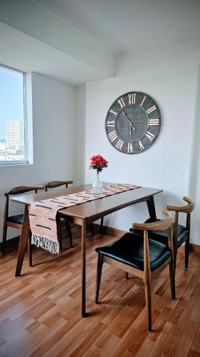 a dining room with a table and a clock on the wall at Sumaran II in Lima