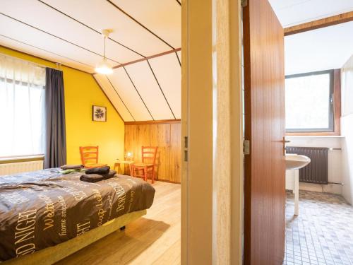 a bedroom with yellow walls and a bed in a room at Steenenburg Zicht in Nieuwkuijk