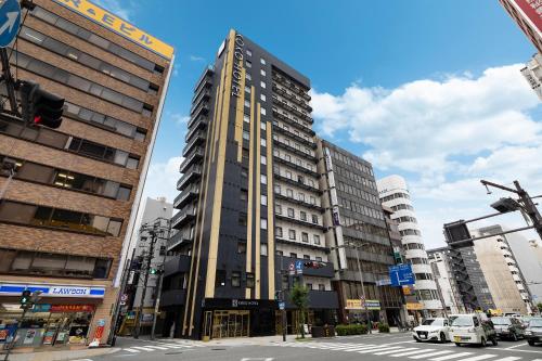 a tall building in the middle of a city at KOKO HOTEL Osaka Umeda - formerly Hotel Wing International Select Osaka Umeda in Osaka