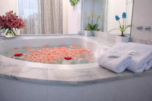 a bathroom with a bath tub filled with flowers and towels at Hotel Picadão in São Pedro