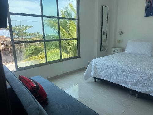 a bedroom with a bed and a large window at Hostel La Catalina Plus - frente al mar in Cartagena de Indias
